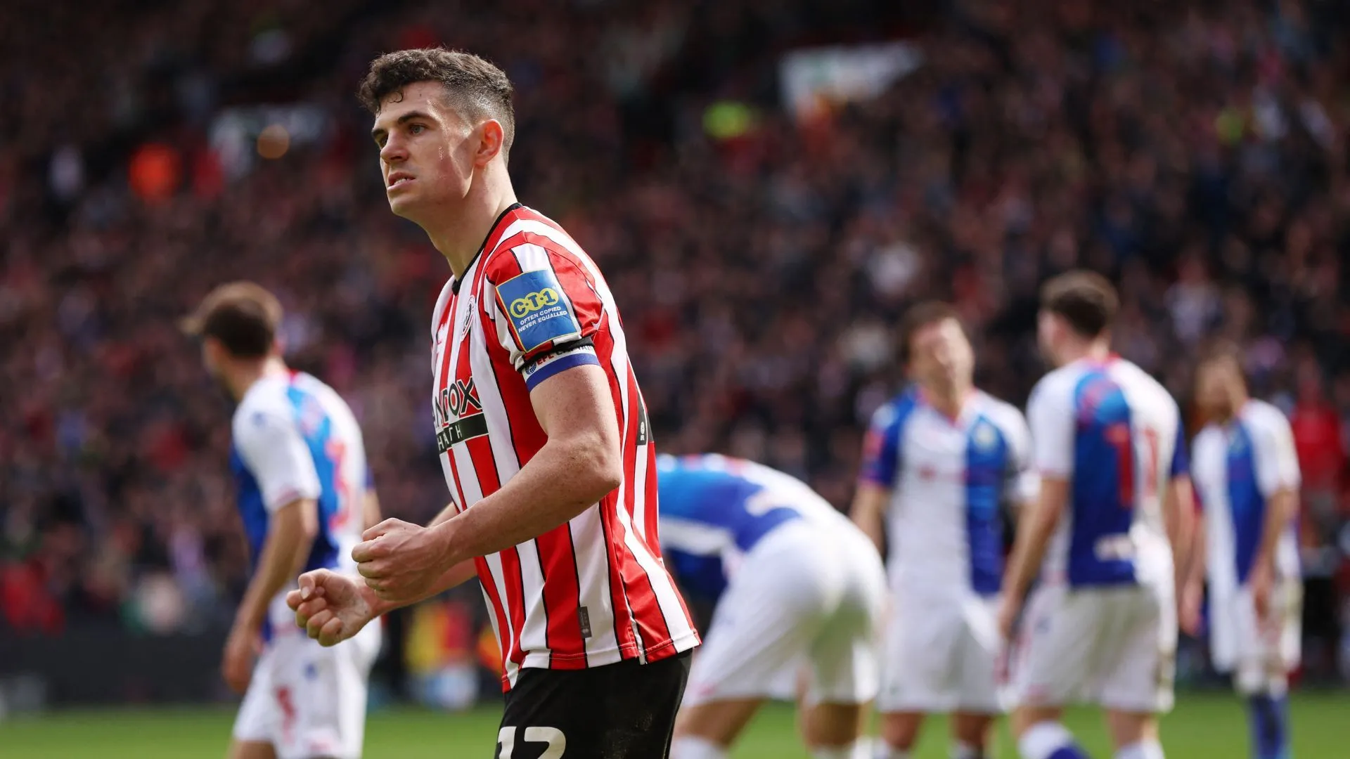 Hậu vệ John Egan trong màu áo Sheffield United tranh chấp bóng trên sân.